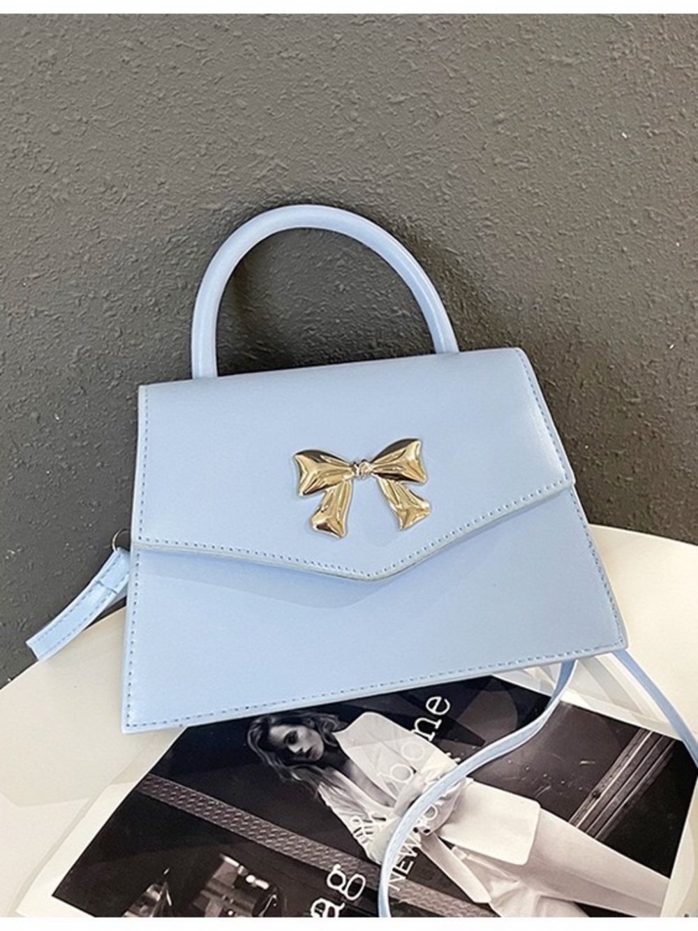 Elegant Light Blue Top-Handle Bag with Gold Bow Accent